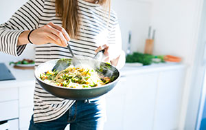 Woman cooking a healthy meal in a wok