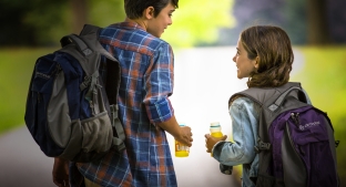 two young children drinking beverages