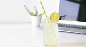 Clear drink with lime and a straw