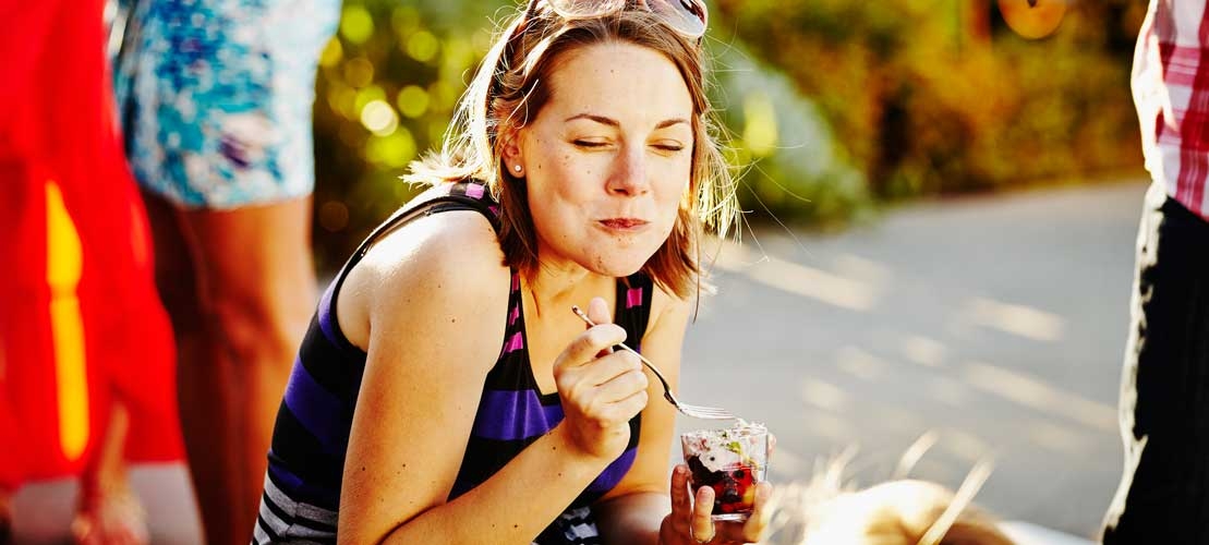 Woman enjoying yoghurt in sunshine