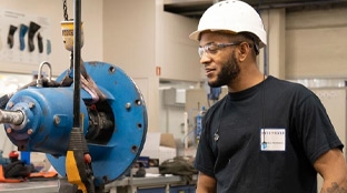 Black colleague operating industrial machinery